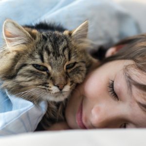 cat sleeping on woman's head